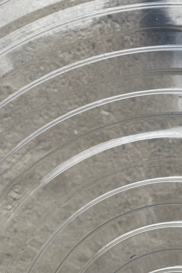 A detailed view of the interior ridges of Plastic saucer 17" against concrete backdrop