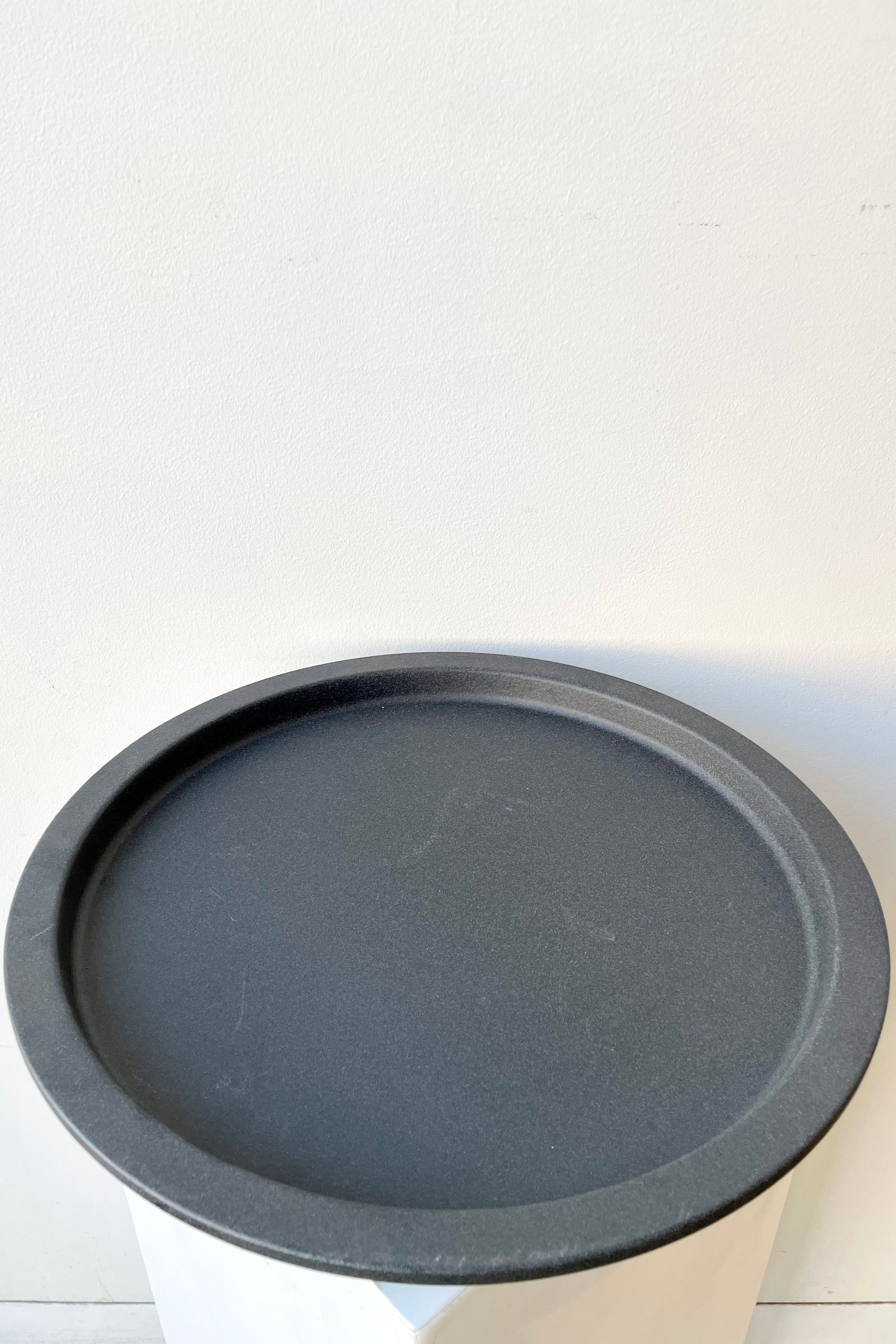 The grey speckled saucer against a white wall at Sprout Home