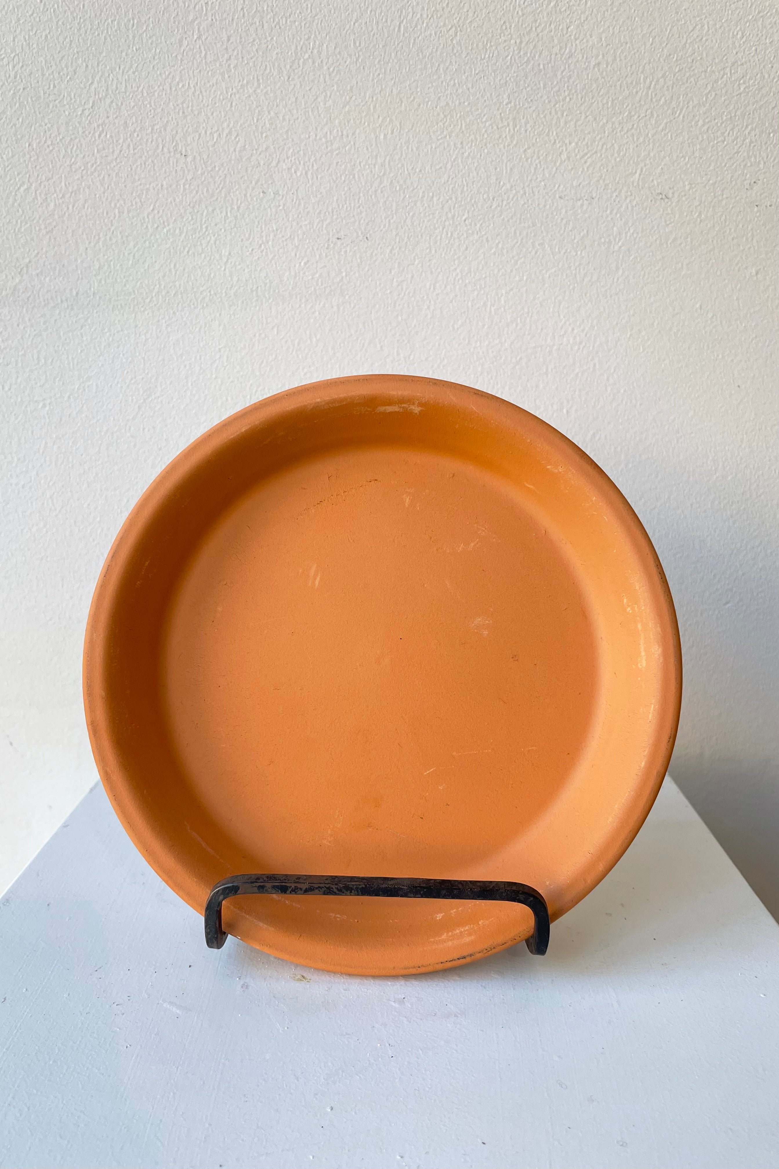 Clay Standard Saucer Terracotta 6.7" against a white wall