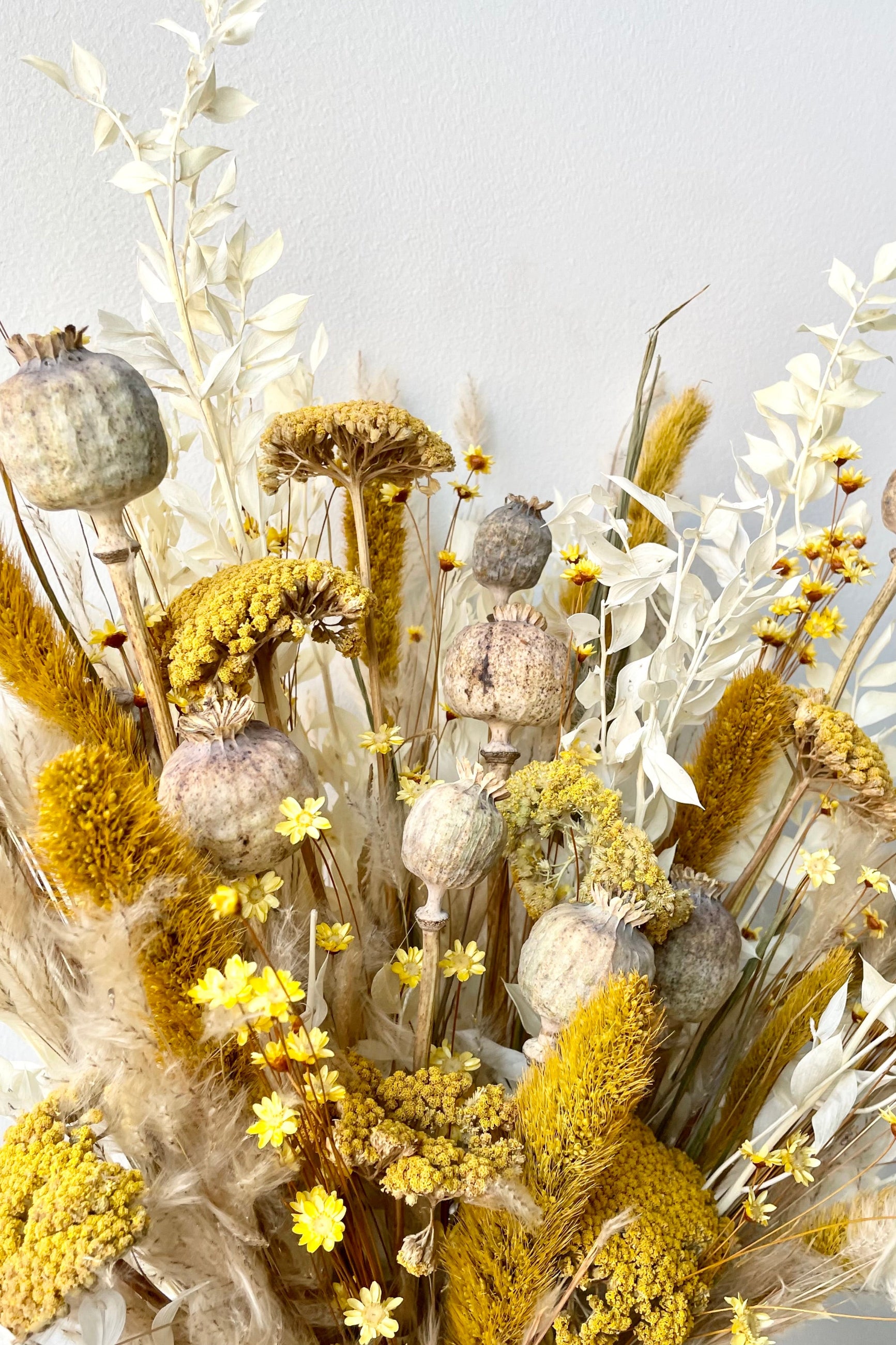 A dried floral arrangement with bright yellows and whites with hints of tan. ©Sprout Home #size_$125