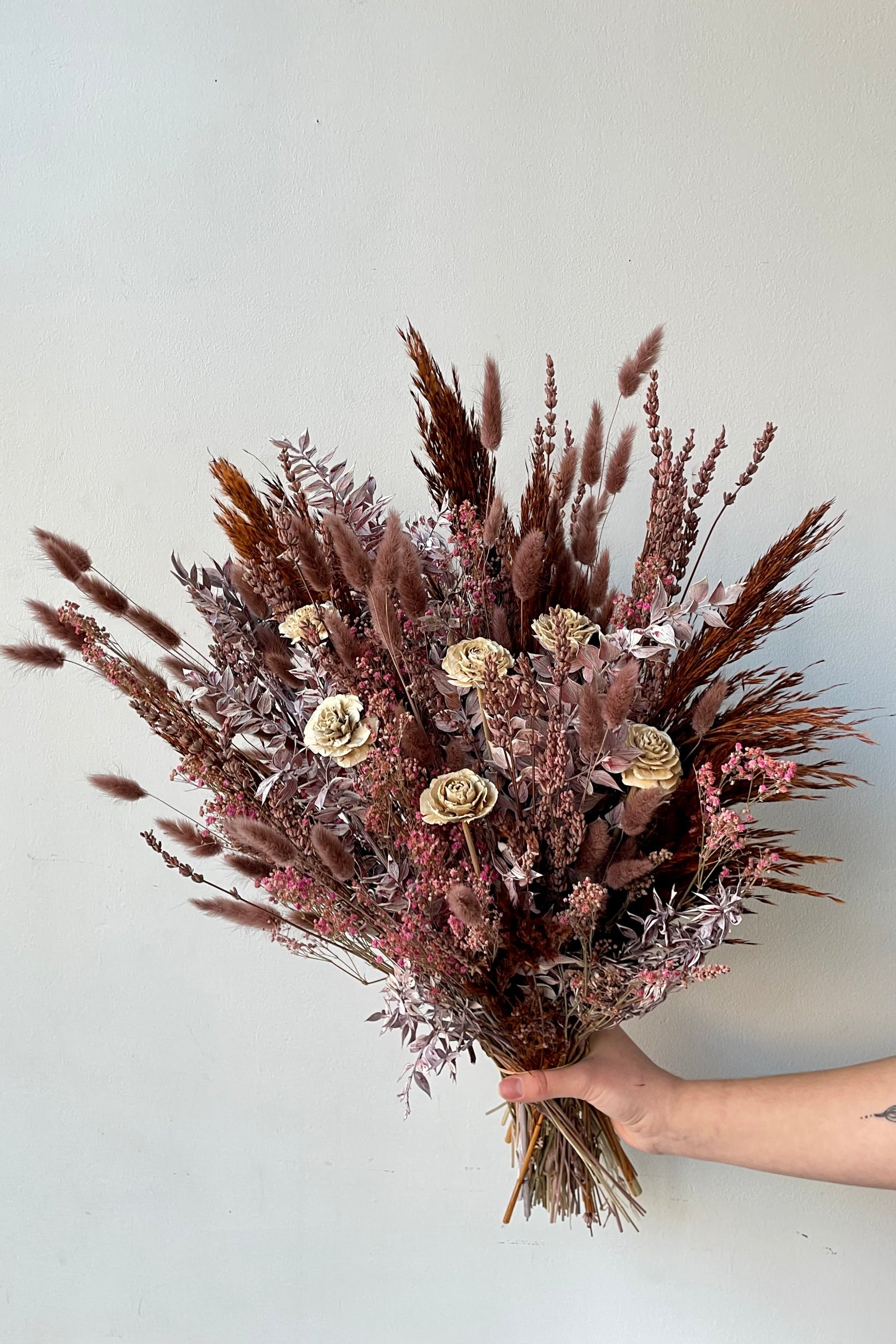 Ambrosia arrangement by Sprout Home being held against a white wall. ©Sprout Home #size_$160