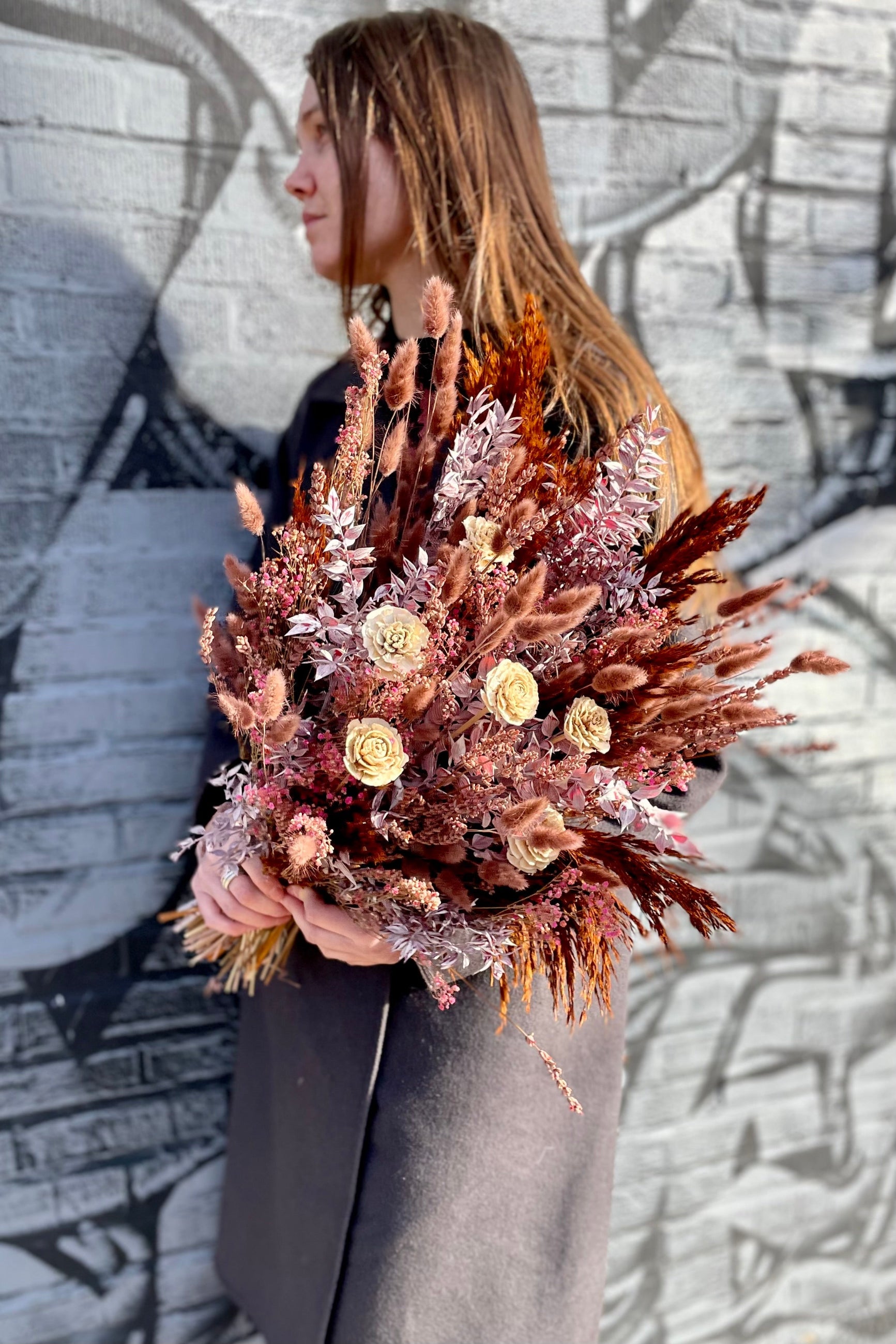 Sprout Home Ambrosia arrangement being held by JJ against a graphic gray wall.©Sprout Home #size_$160