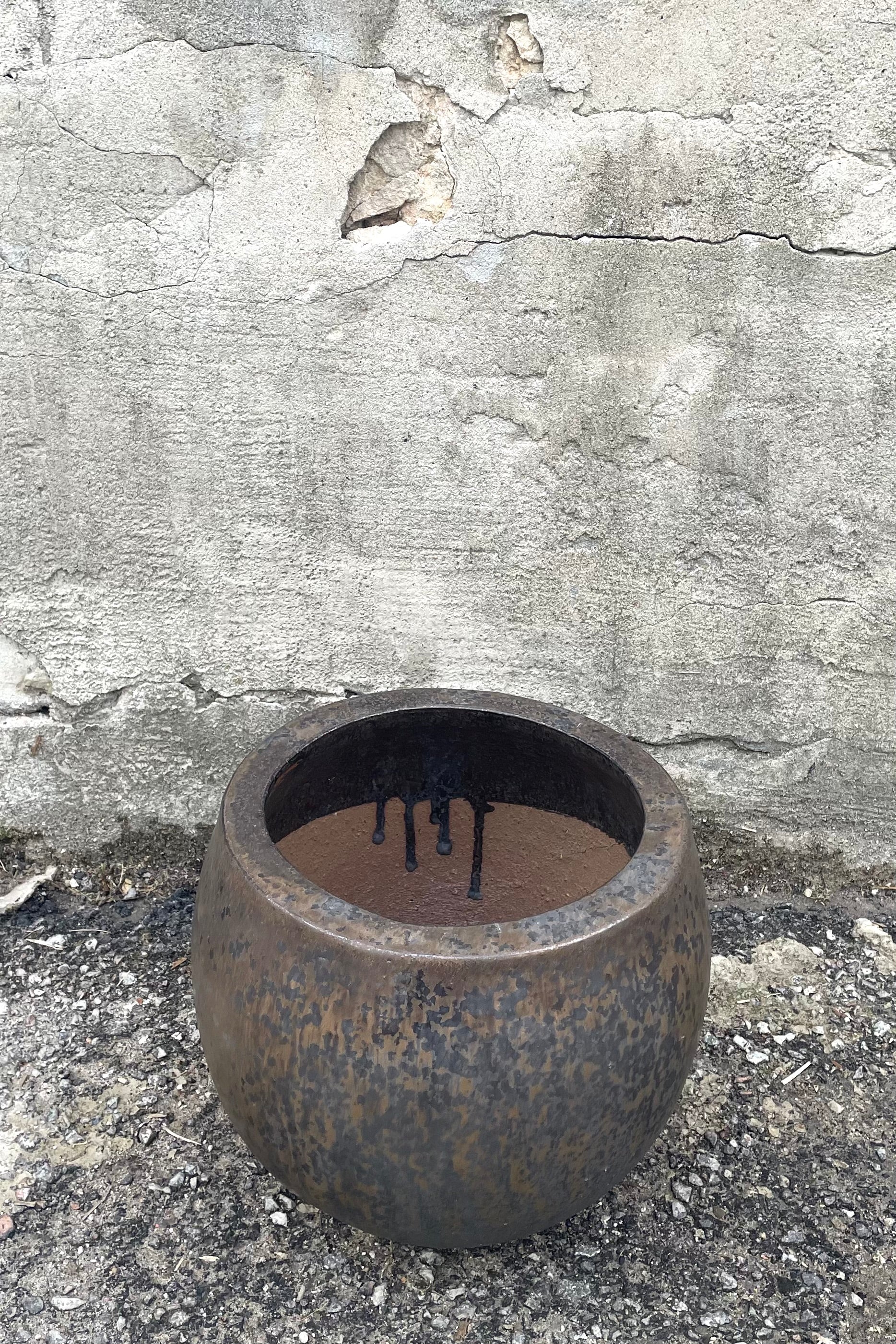 A slight overhead view of Luna Cercle Planter Small against concrete backdrop