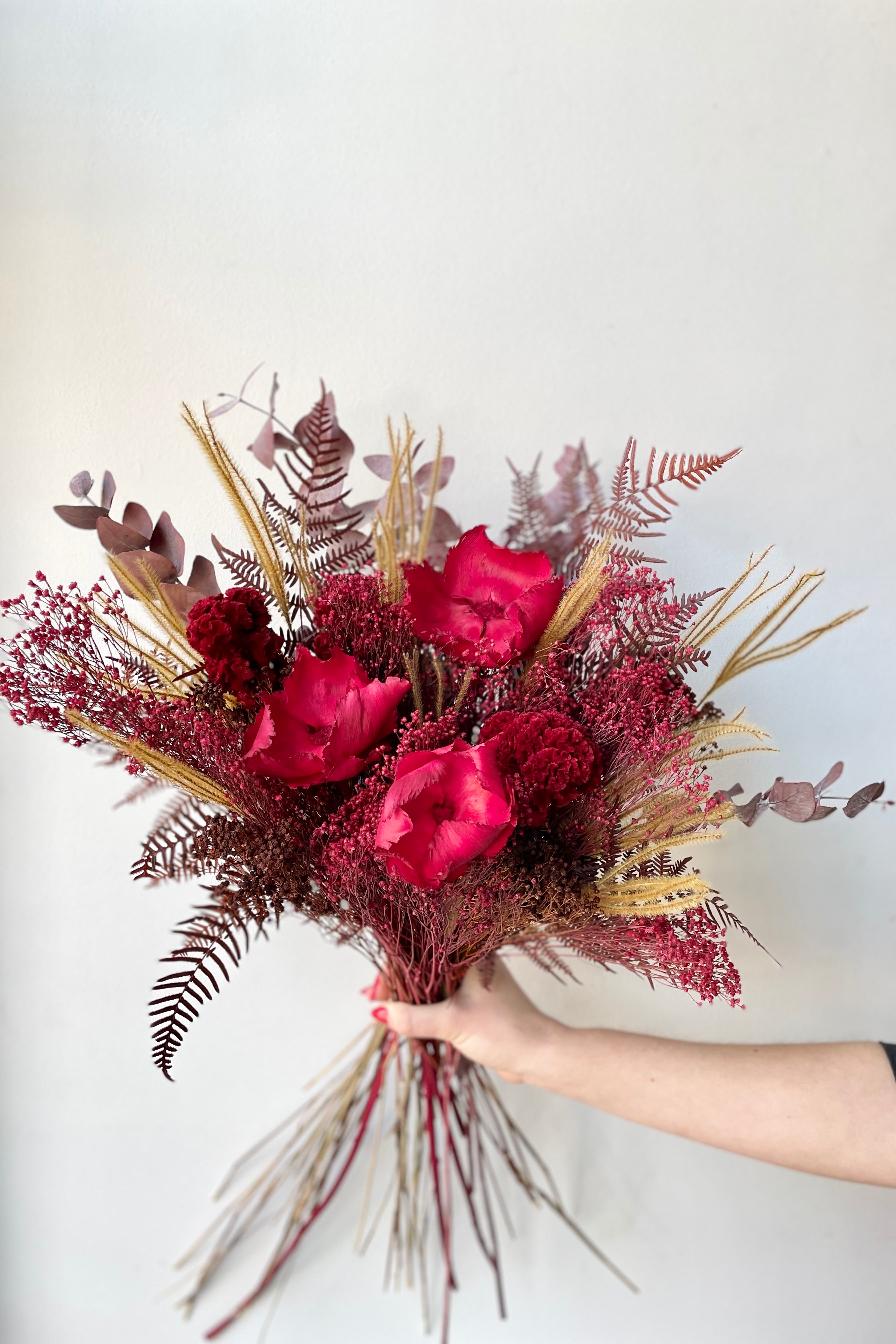 Preserved Red Velvet arrangement against a white wall #size_$125
