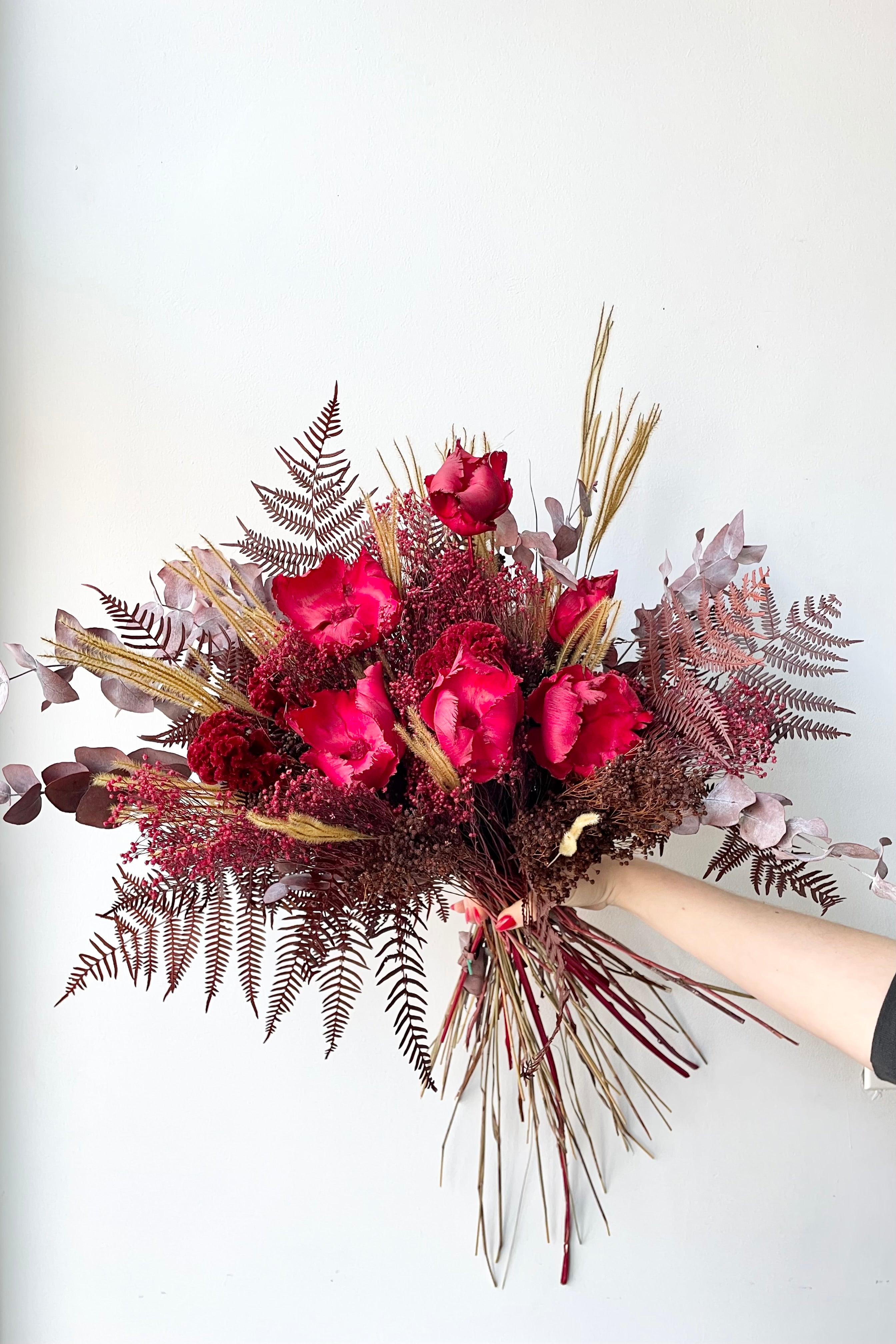 Preserved Red Velvet arrangement against a white wall #size_$160