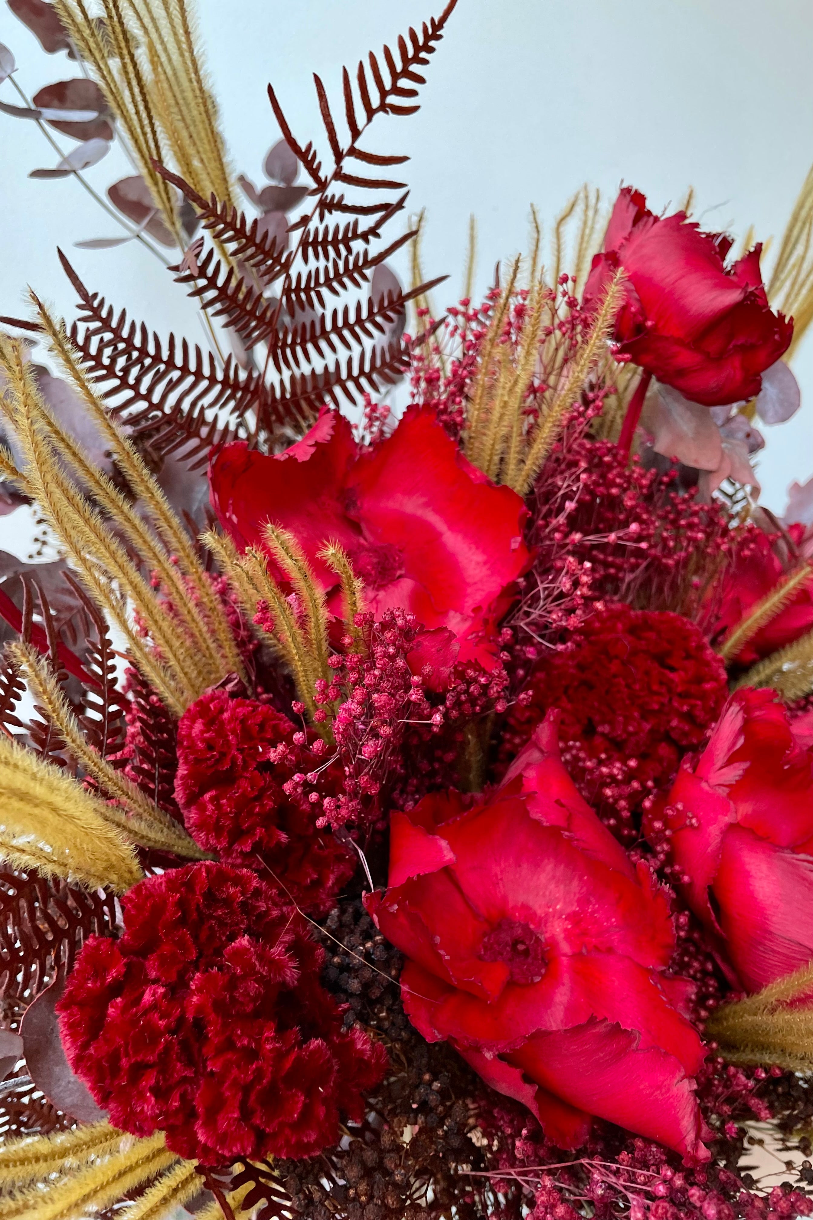 Preserved Red Velvet arrangement detail against a white wall #size_$200