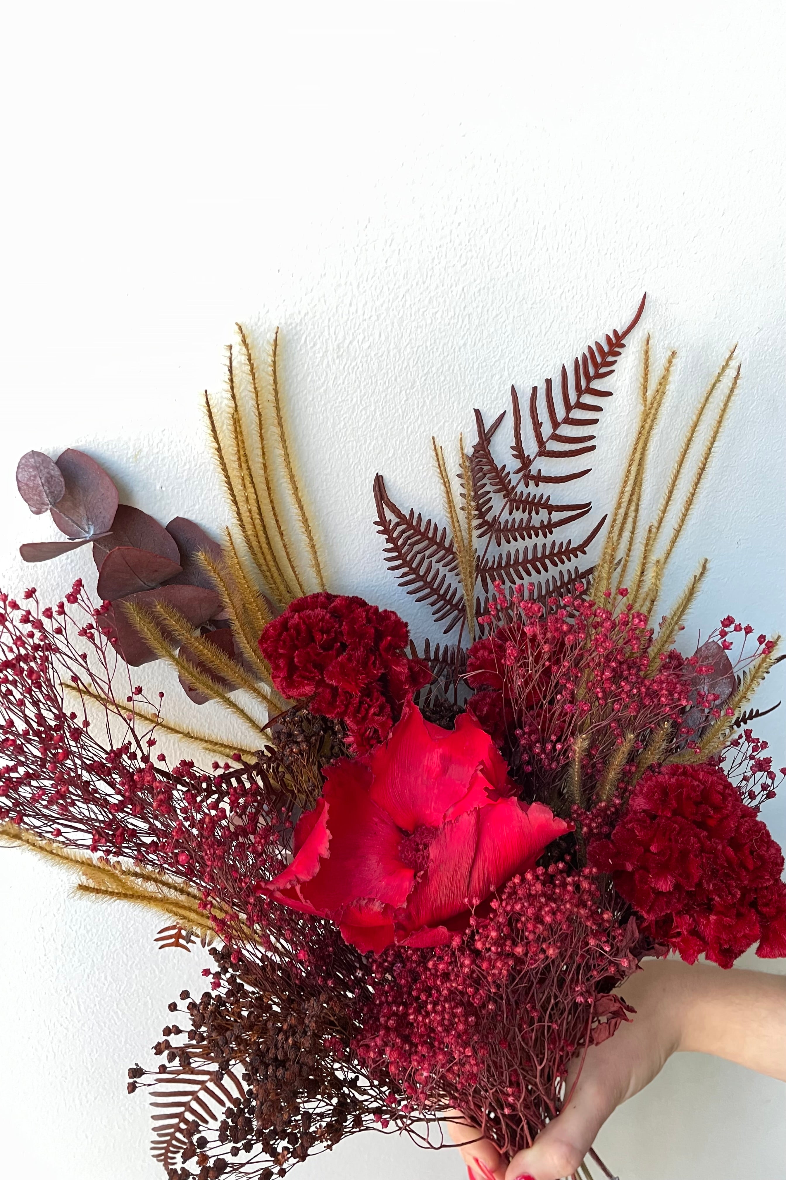 Preserved Red Velvet arrangement detail picture against a white wall #size_$60