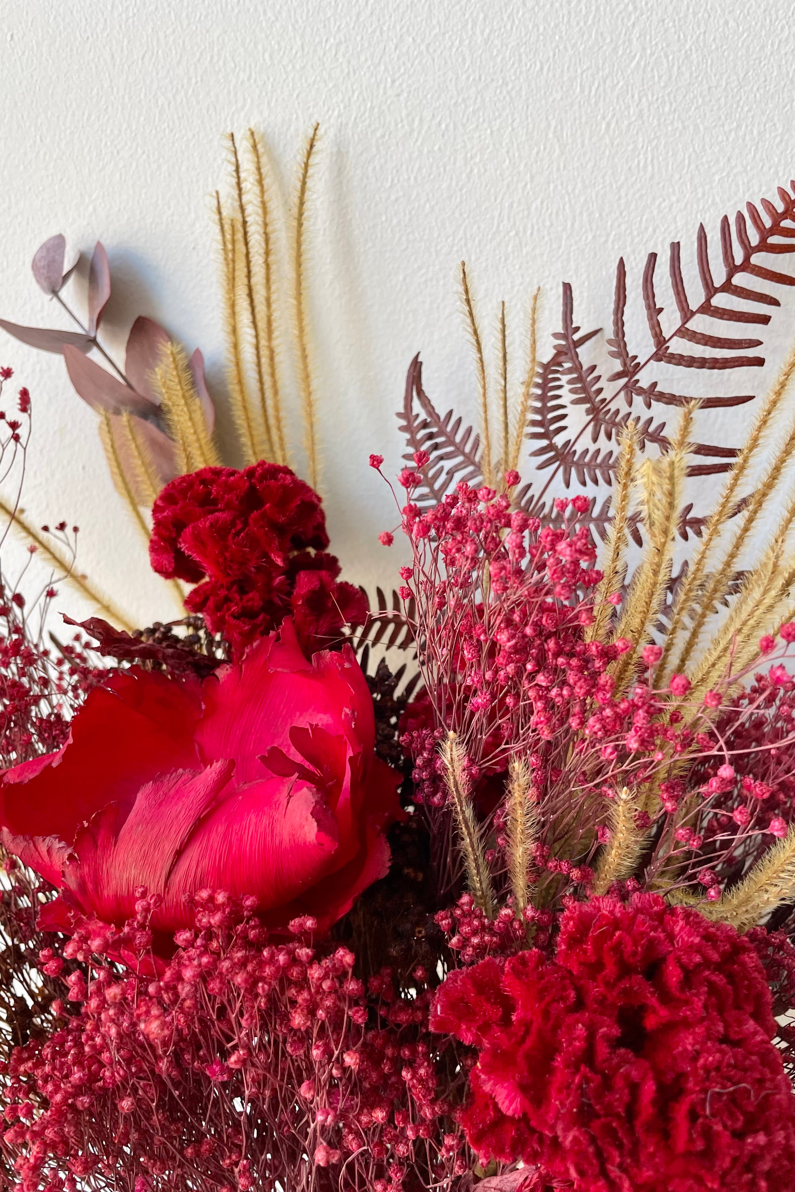Preserved Red Velvet arrangement detail against a white wall #size_$60