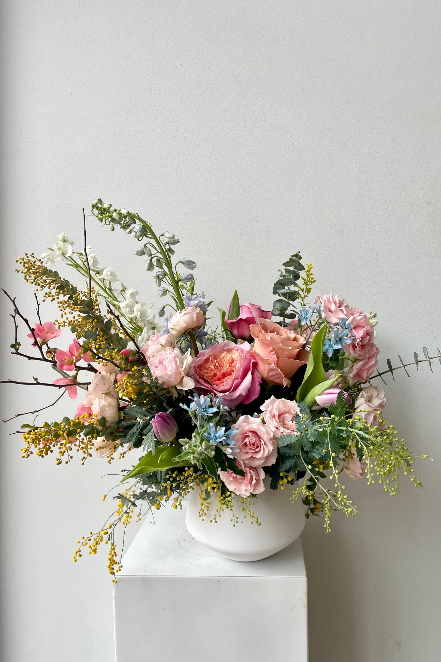 An example of Floral Arrangement Dawn from Sprout Home in Chicago. The arrangement is made of pastel yellow, purple, green, pink, and white flowers with green foliage. ©Sprout Home #size_$200