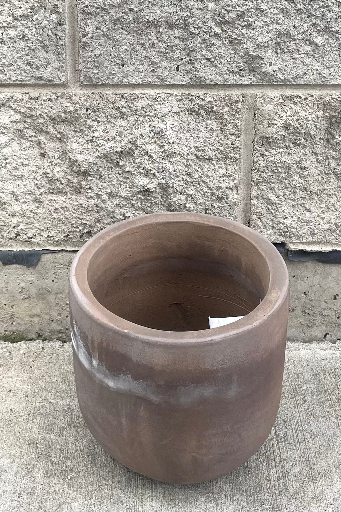 A slight overhead view of Dora Planter Small against concrete backdrop