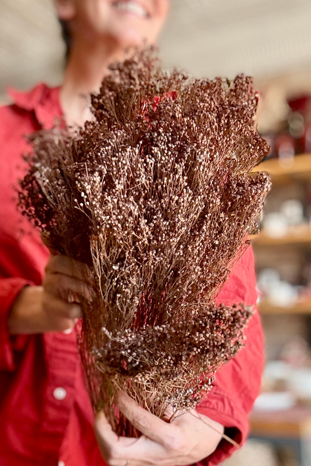 Person holding a Brooms Dusty Rust Color Preserved Bunch in a store setting ©Sprout Home