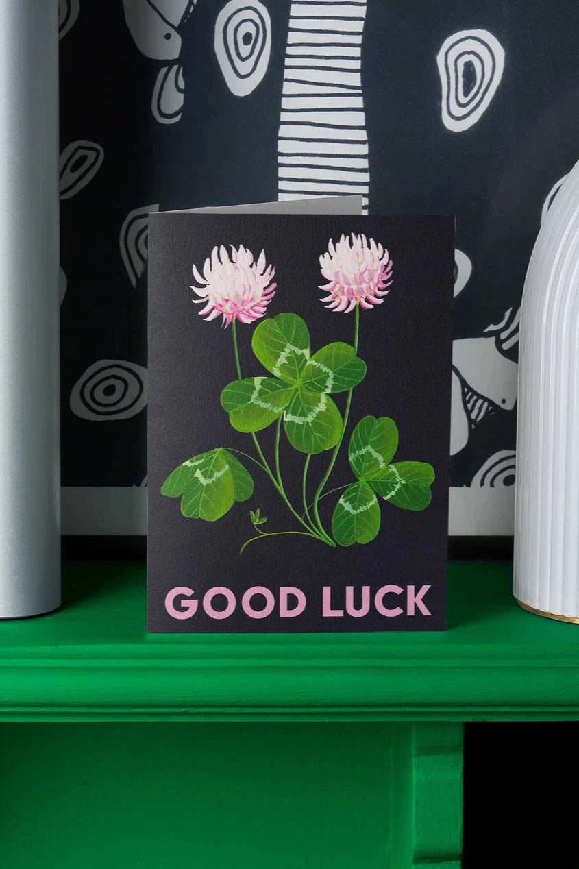 Lucky Clover greeting card by Stengun Drawings in a lifestyle shot sitting on a green ledge