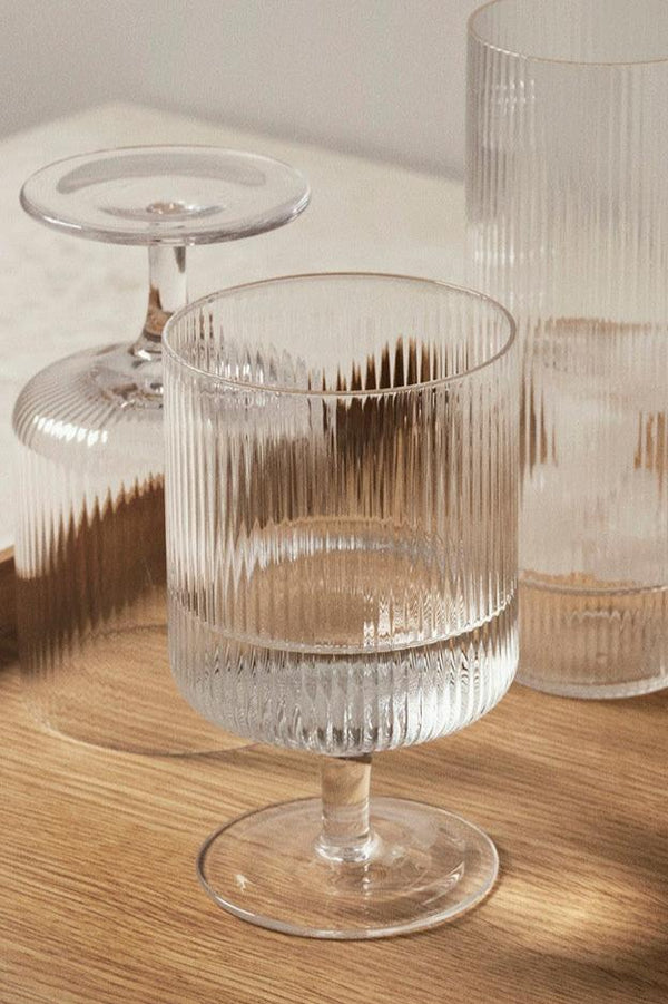 A set of clear Wine Ripple Glasses by Ferm Living. One upside down and right side up.