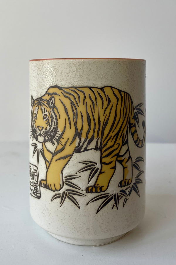 Photo of tiger tea cup against a white wall