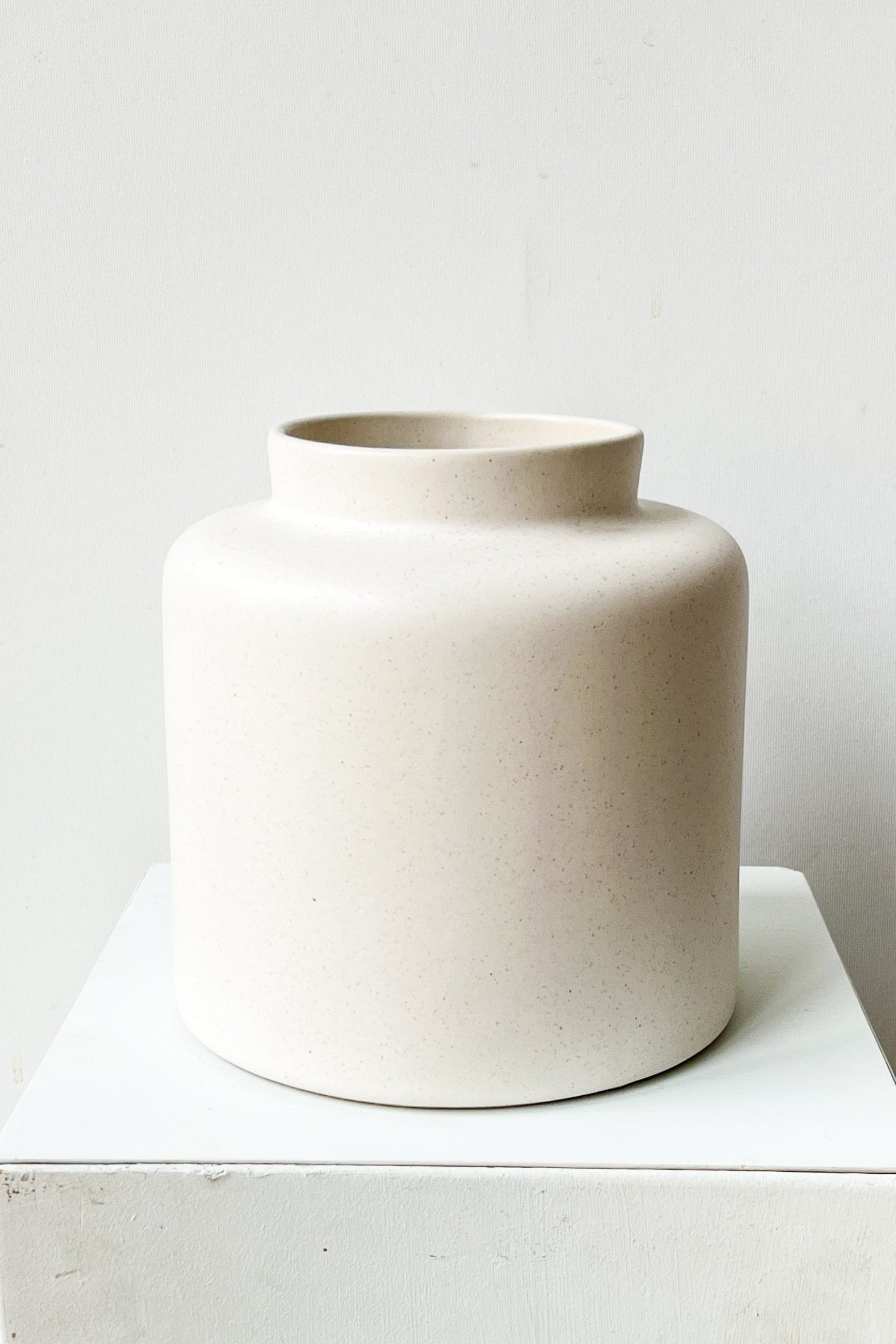 Beige ceramic vase on a white surface with a white background ©Sprout Home