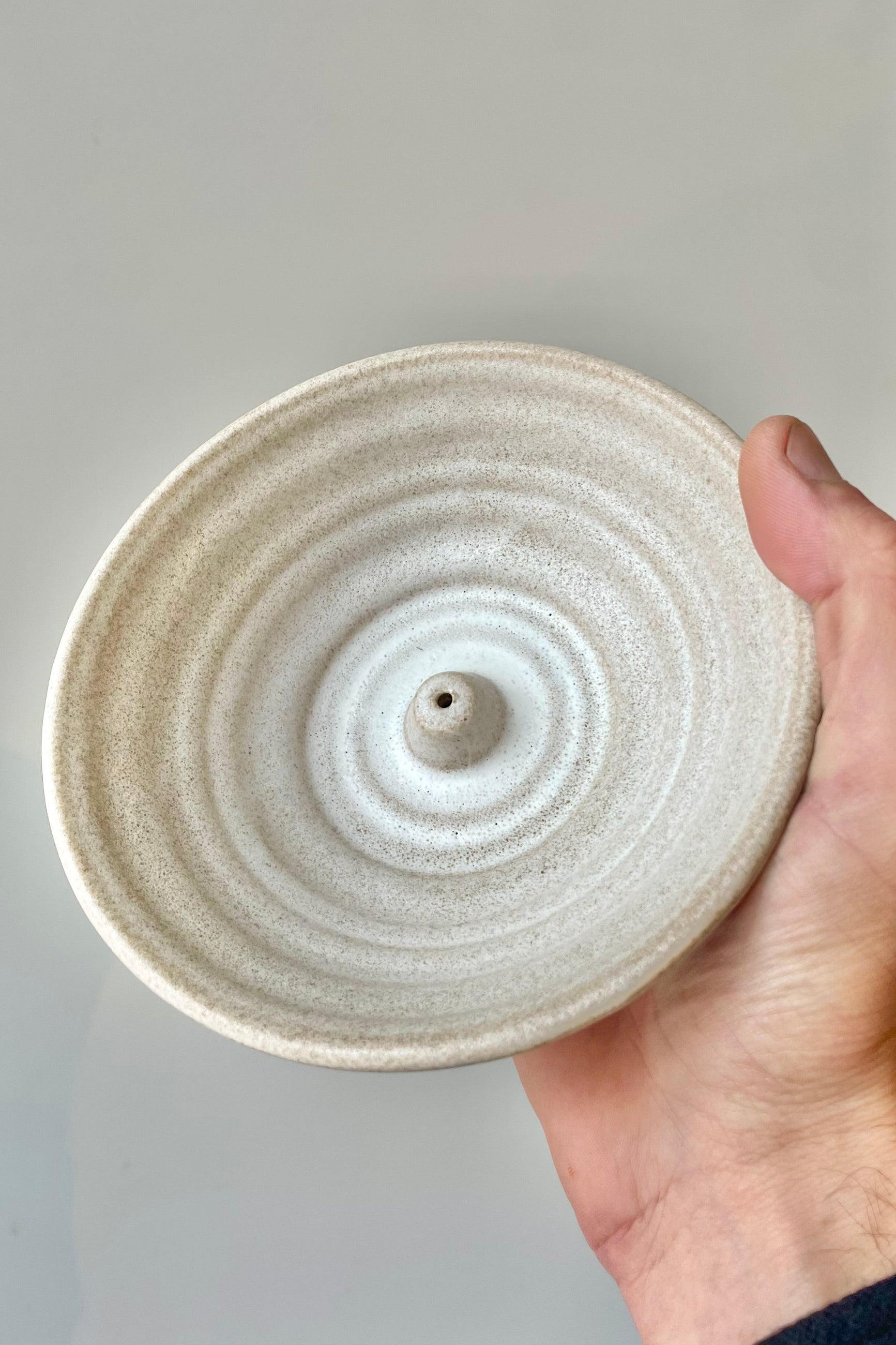 Hand holding a ceramic incense dish ©Sprout Home
