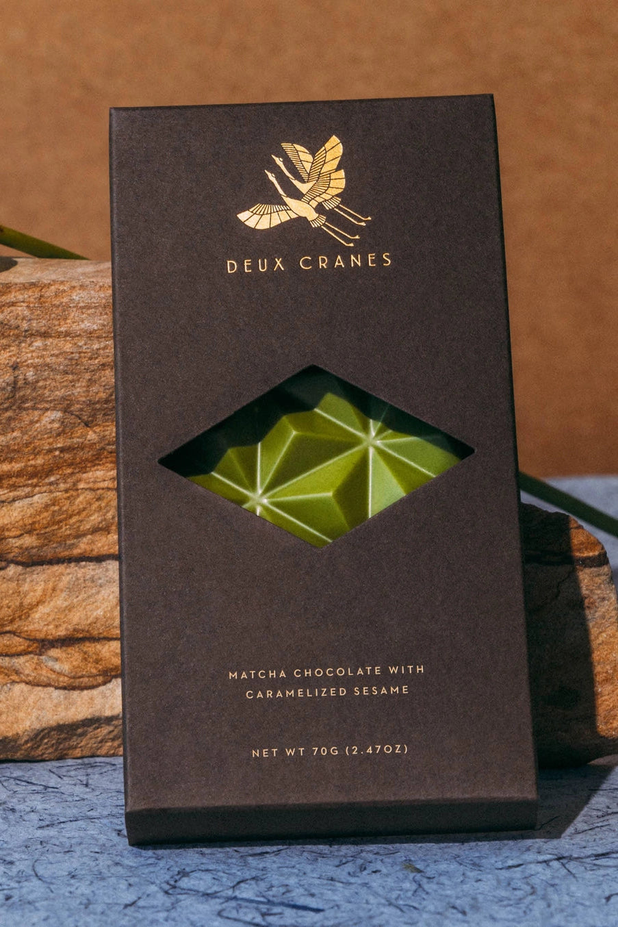 Deux Cranes matcha chocolate bar packaging on a wooden surface ©Deux Crames