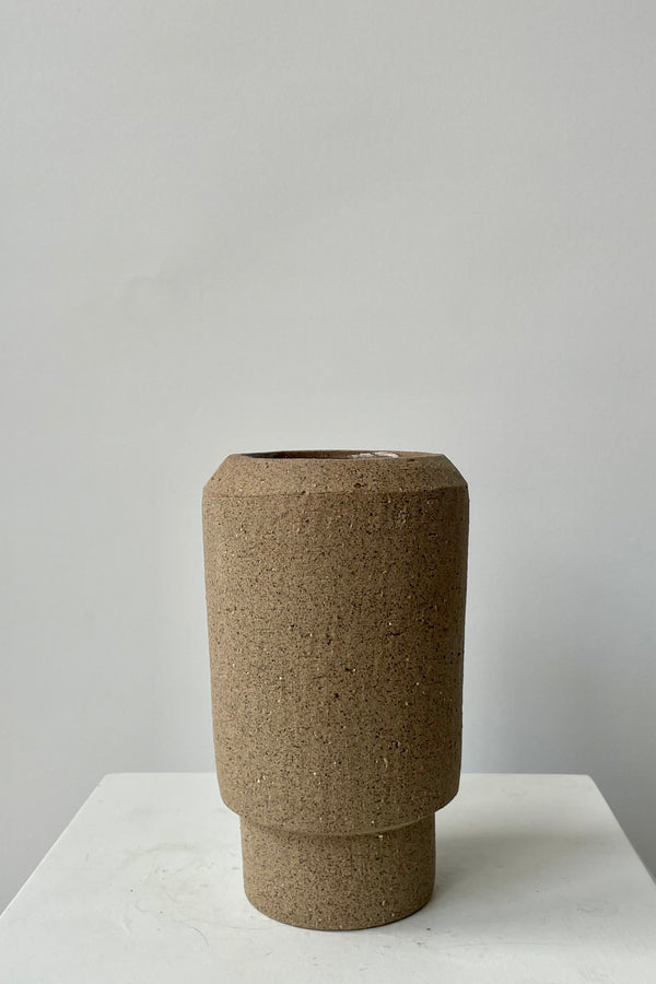 Photo of brown Valdez vase against a white wall.