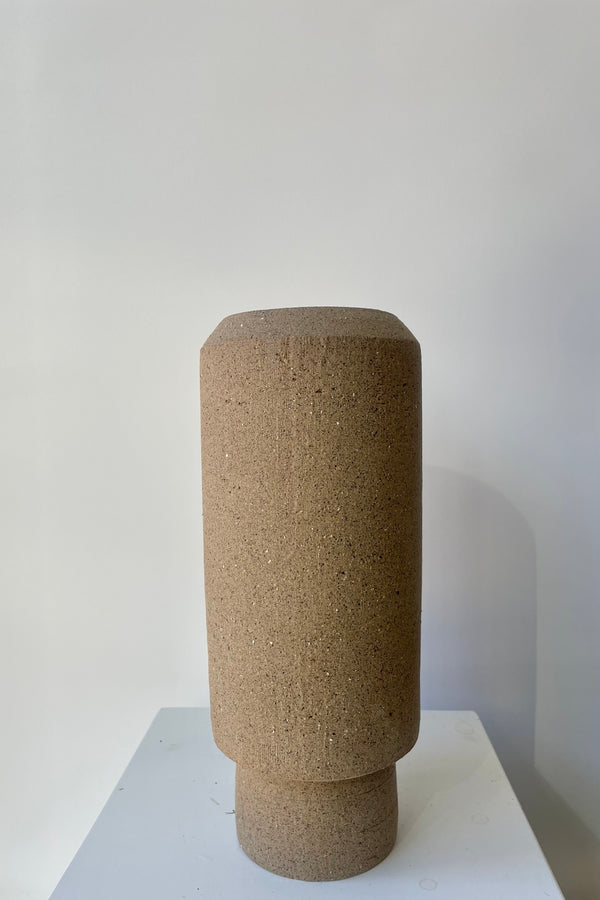 Photo of the natural brown clay Valdez vase against a white wall.