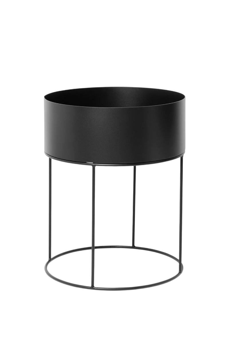 Black round Plant Box by Ferm Living showing the round planter on its stand.