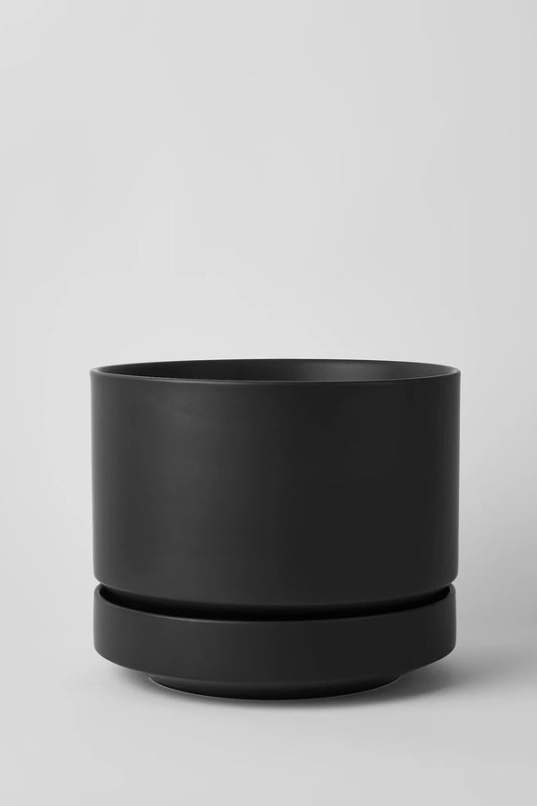 LBE Design Black Round Two Planter empty, shown from the side and against a light grey wall. 