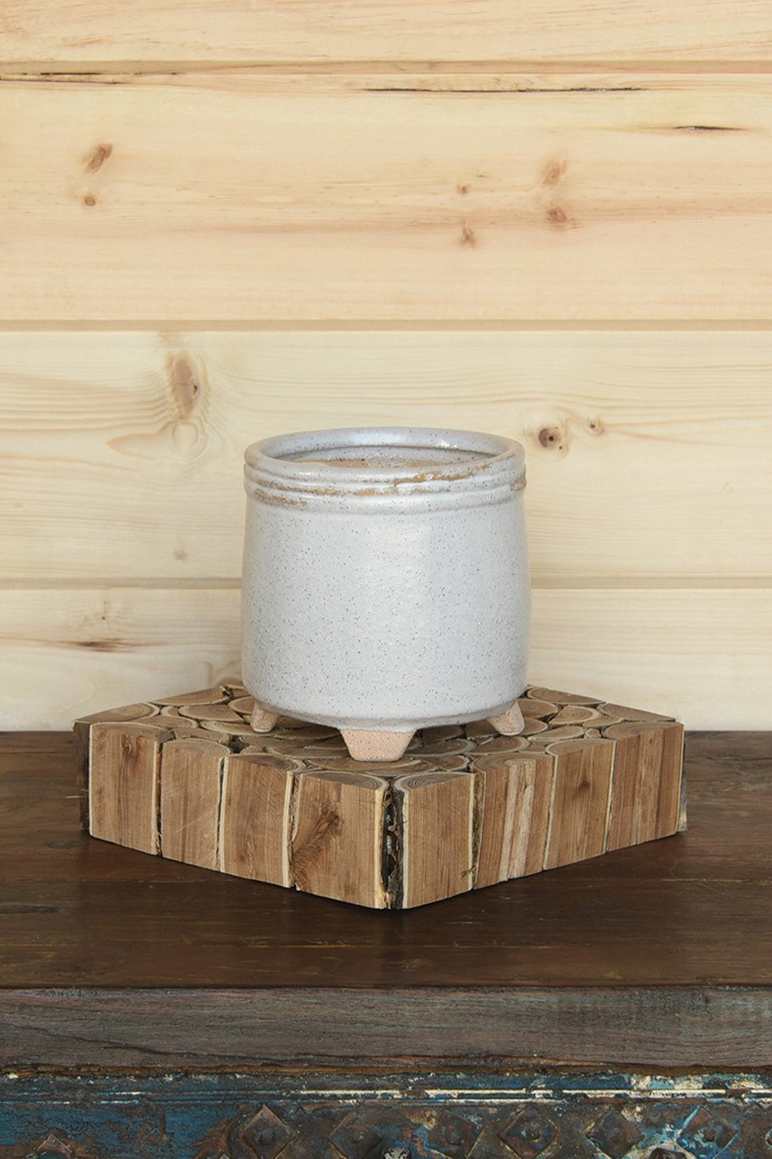 Sur Cachepot in white by Homart. Empty and in a room with a wood wall. 