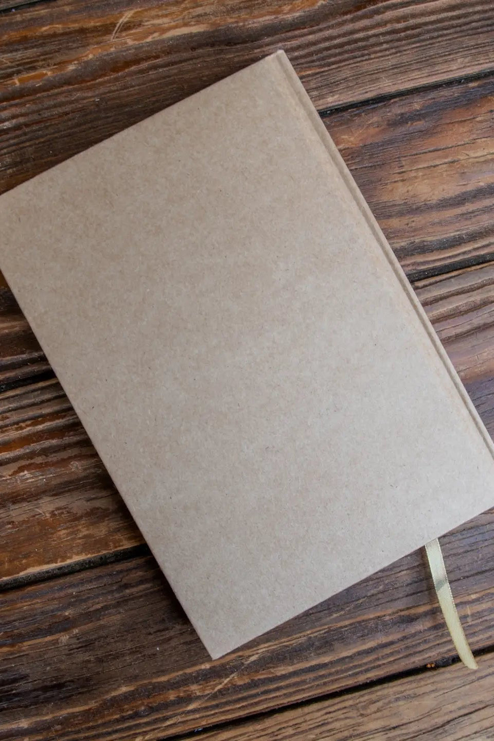 Brown notebook on a wooden surface ©Glum Lot Press