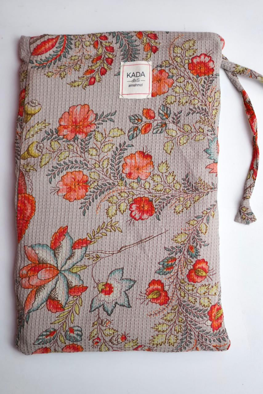 Floral patterned drawstring bag with 'Kada' label on a white background ©Annahmol