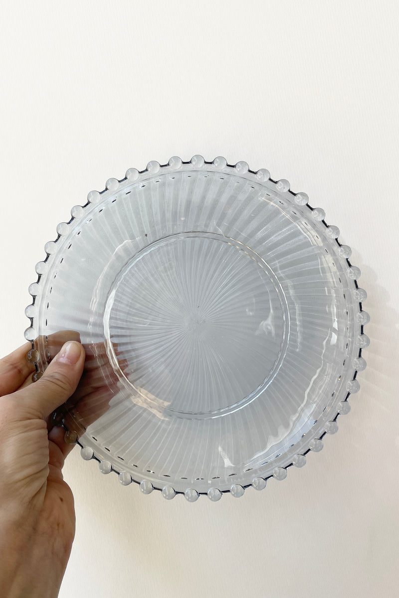 Dentelle Aquamarine Aurora Glass plate being held against a white wall