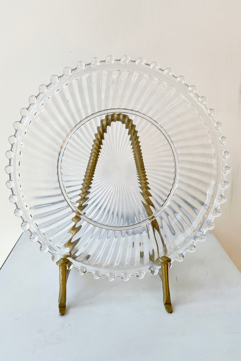 Dentelle clear aurora glass plate on a display stand.