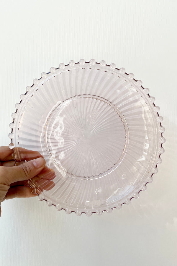 Dentelle Blush Aurora Glass Plate viewed from above against a white wall.