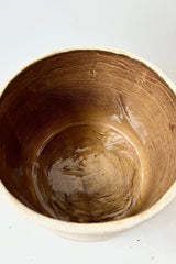 Interior of stoneware cachepot with brown, glazed interior. Does not contain drainage holes.