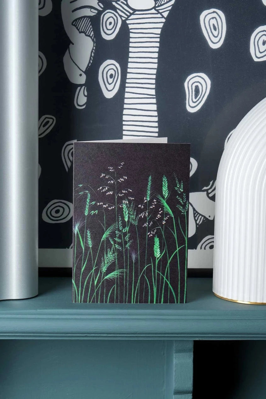 Chelsea Grasses card by Stengun Drawings on a shelf in front of black and white wall paper.