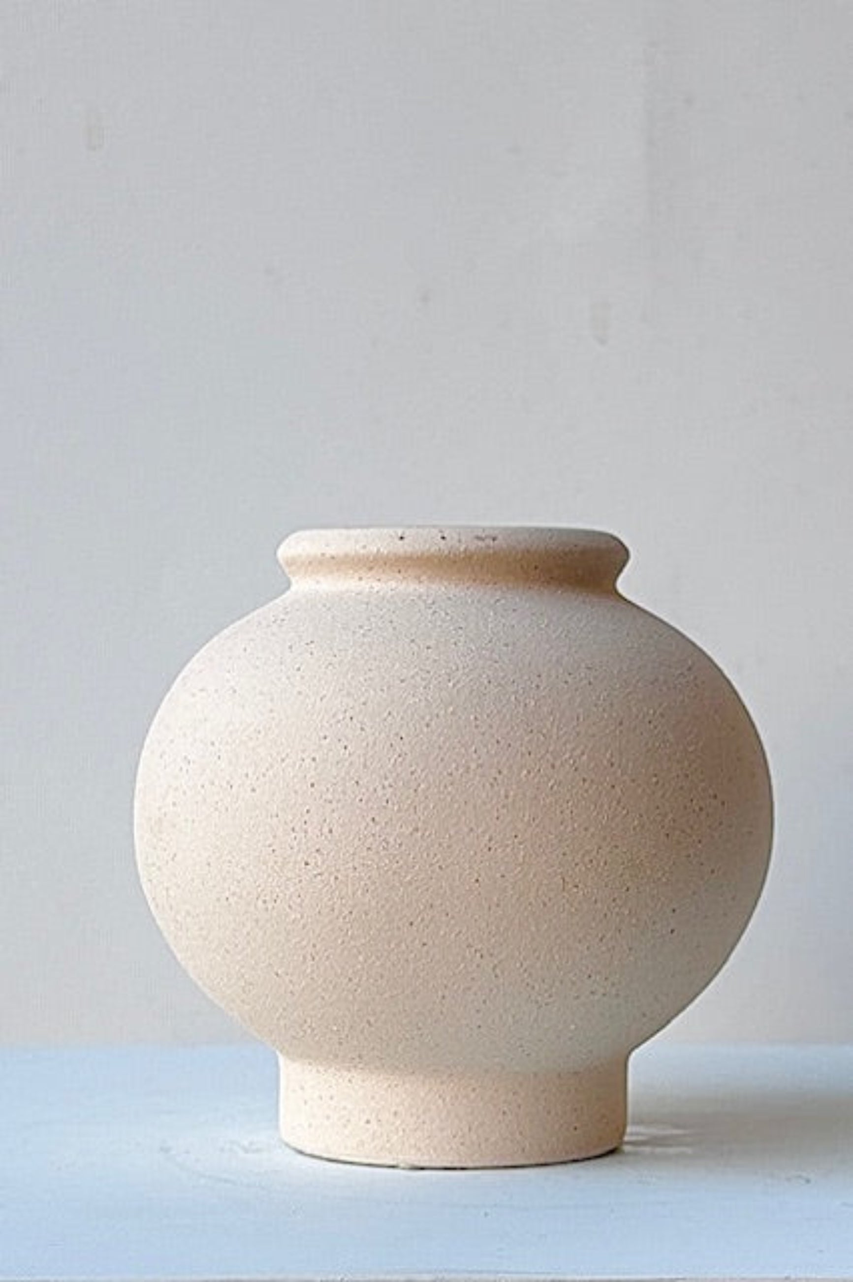 Close up of small beige Stockton ceramic vase on a marble surface ©Sprout Home