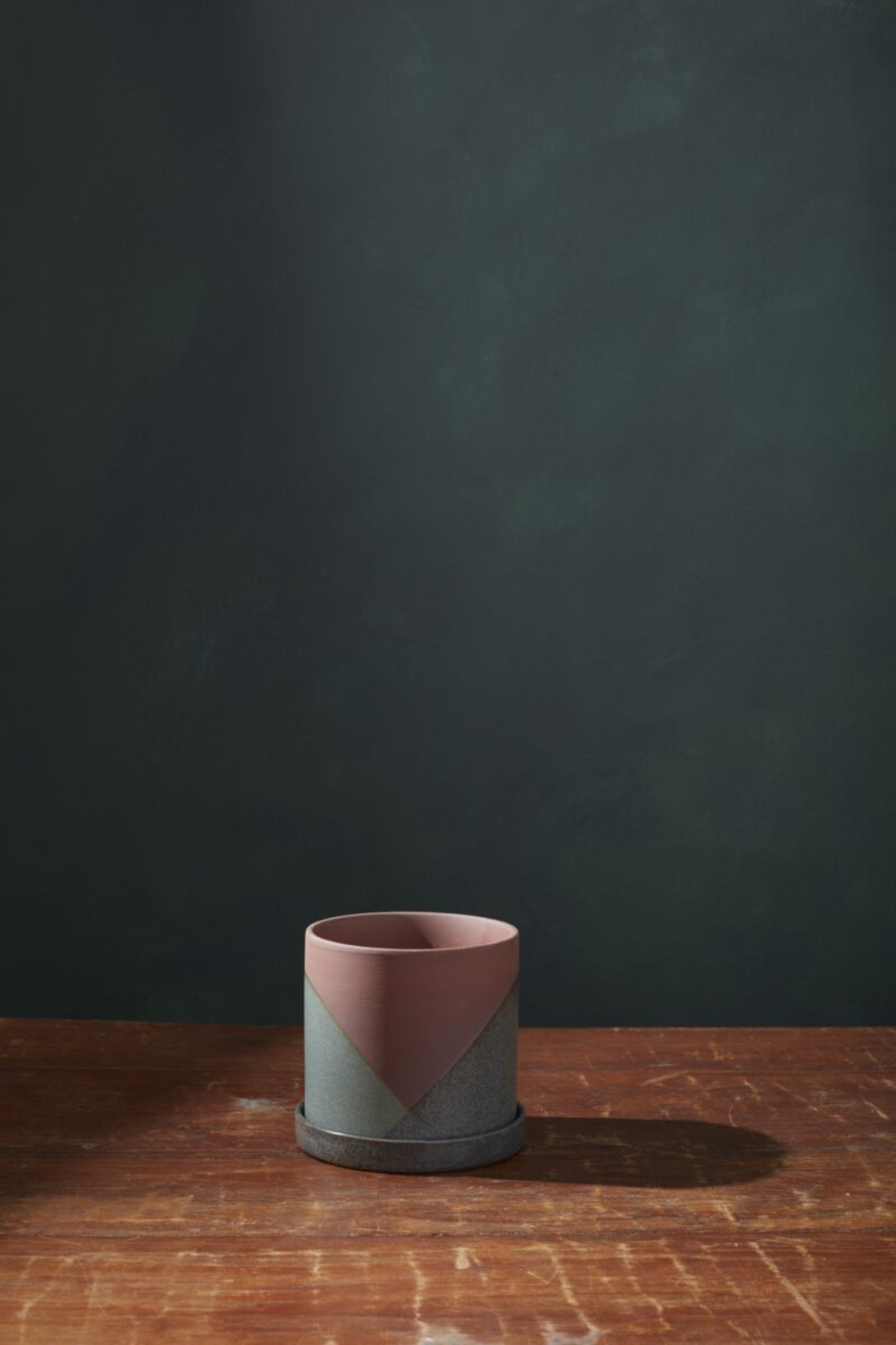 A large El Cerro pot on a wood table and a dark gray background.