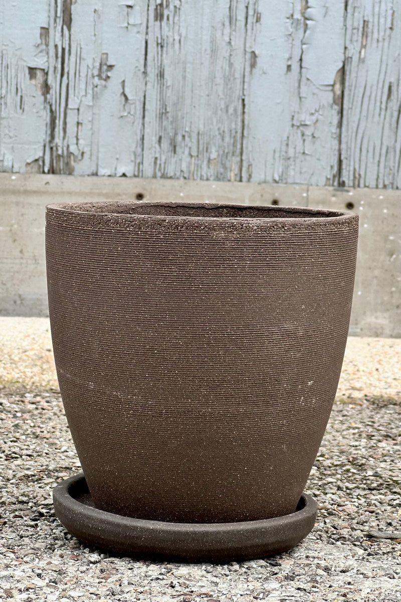 A medium sized Lara carob planter shown from the side at eye level showing off the horizontal ridges. 