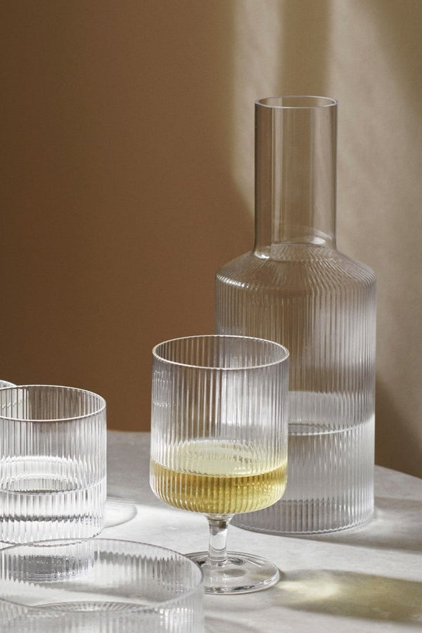 The clear Ripple carafe behind a glass of wine in a Ripple white glass. 