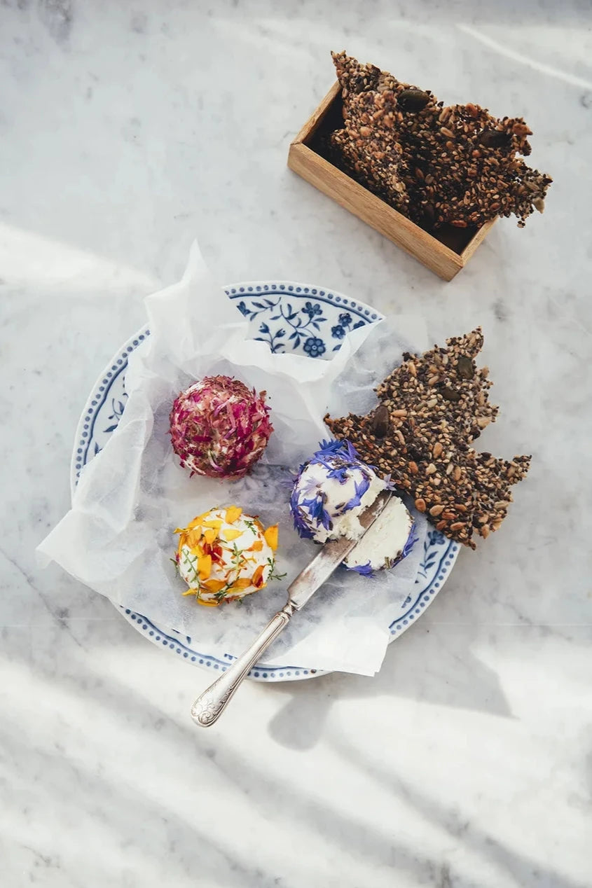 A page from the Flowers on a Plate book showing sweets on top of a white cloth and blue patterned plate.