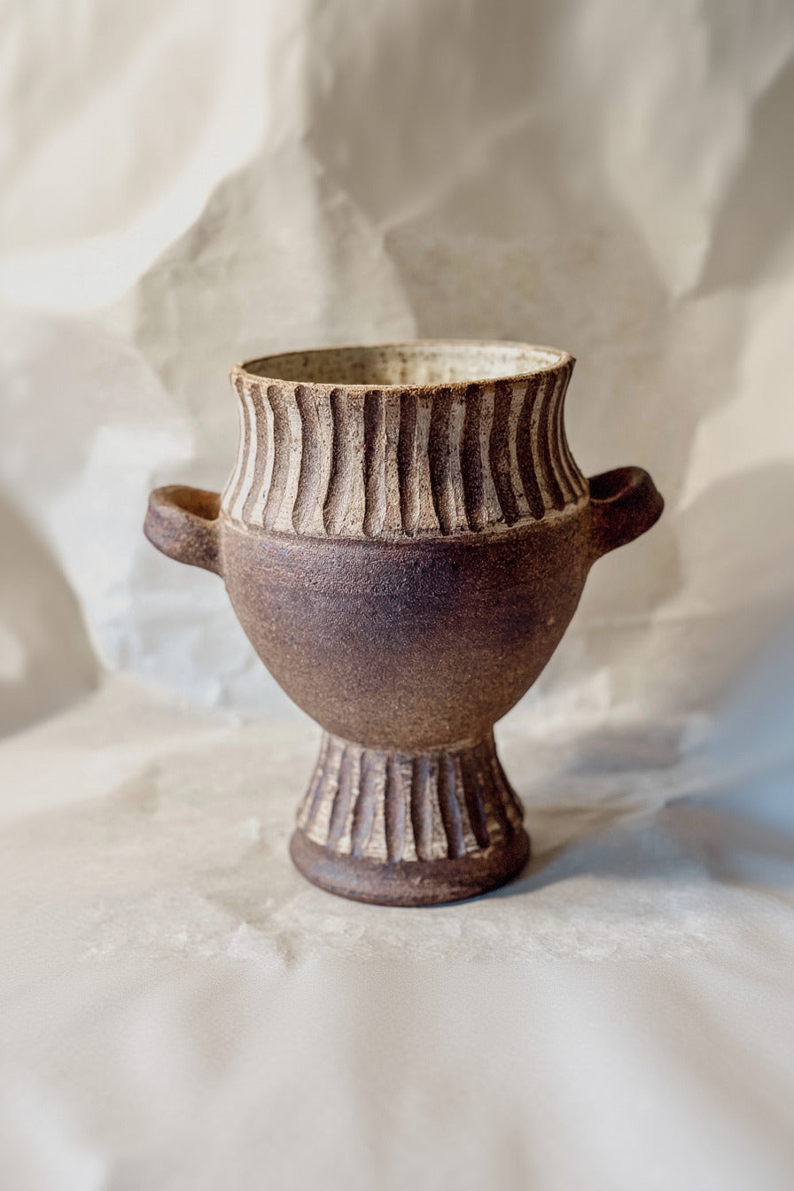 Carved Column Ceramic vase with striped design on a light fabric background ©Olivia Snow Ceramics