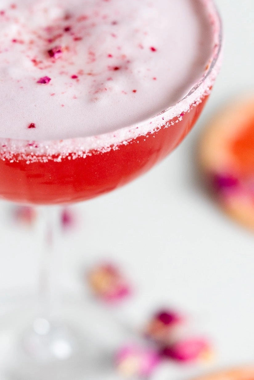 Close-up of a pink cocktail with a white foam top on a white background  ©Flouwer Co.