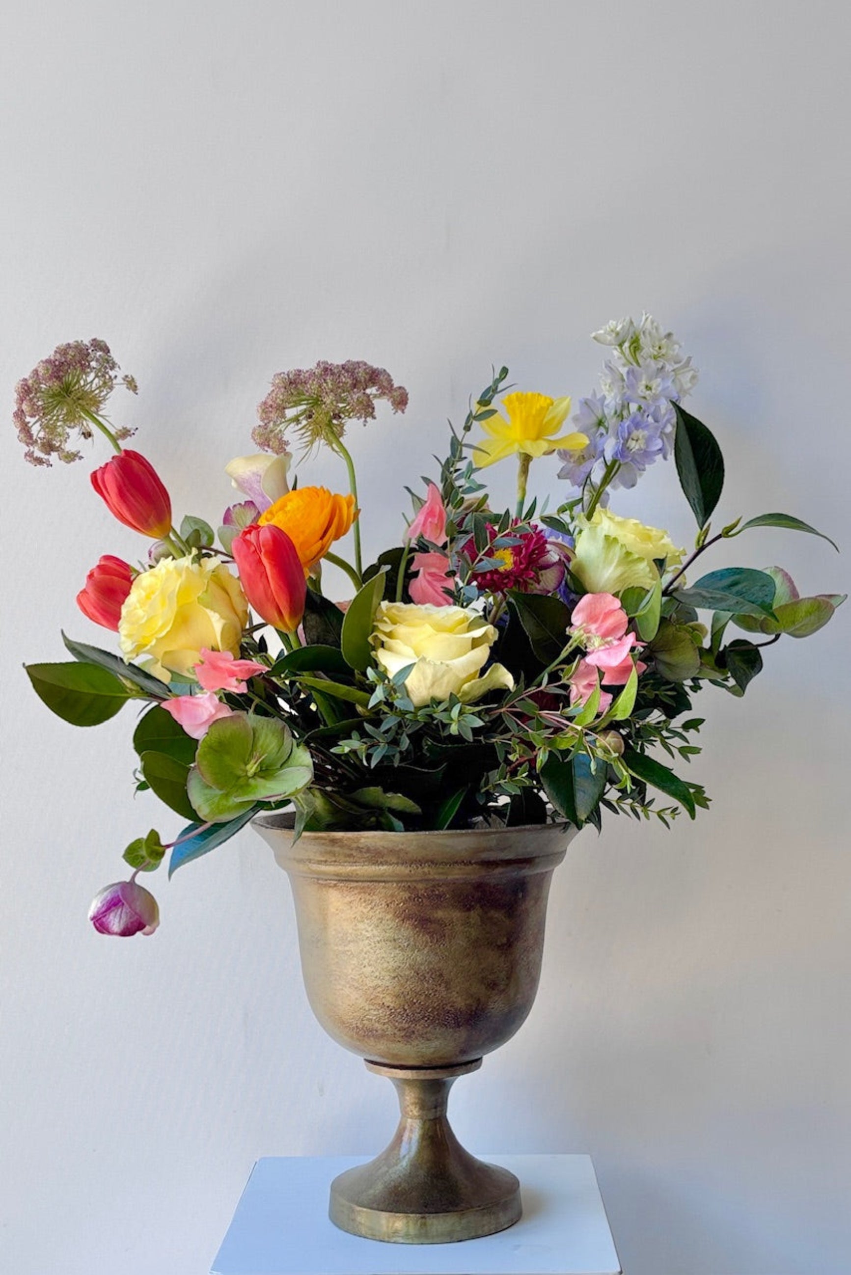 Hullen Bronze urn with a floral display on a white background ©Sprout Home
