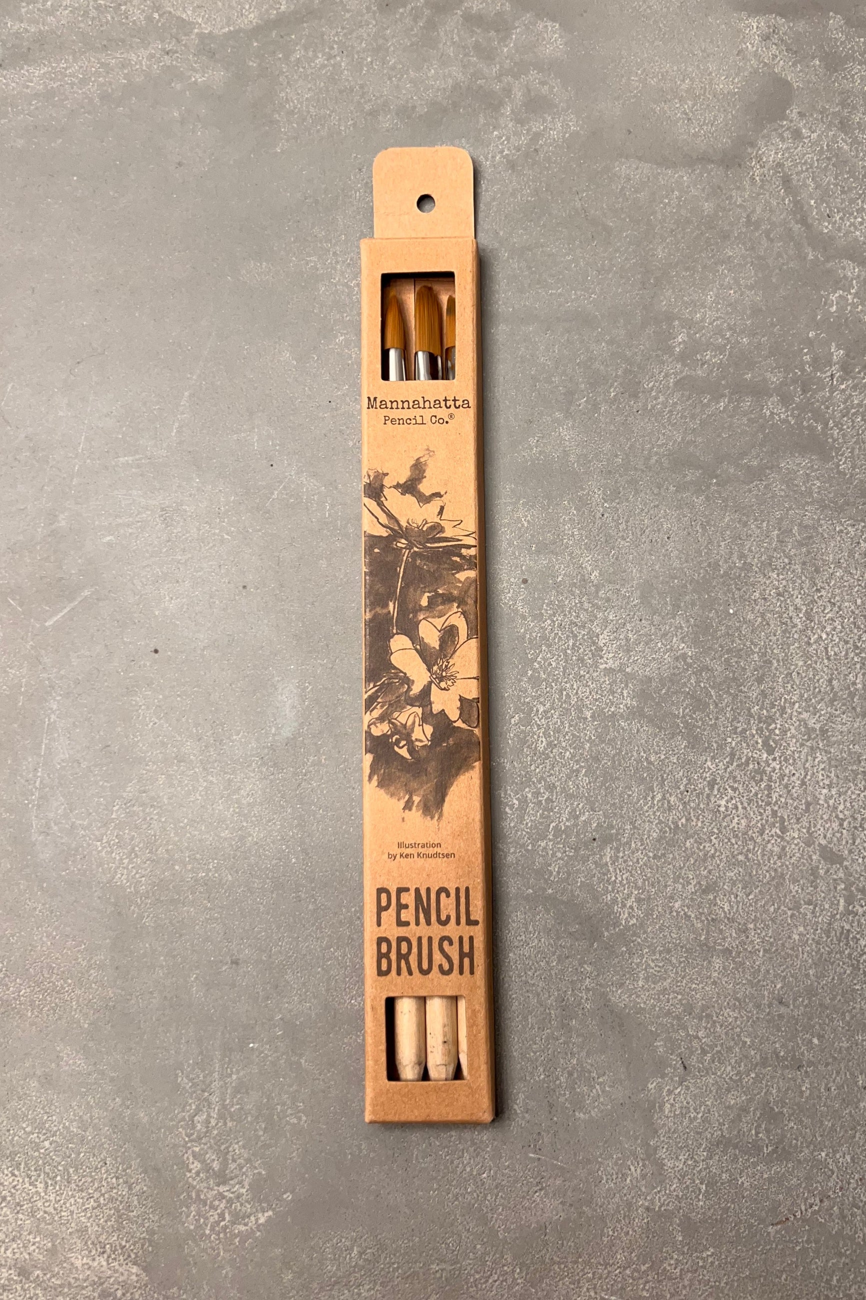 Pencil brush with wooden handle and bristles on a gray textured background ©Mannahatta Pencil Co.