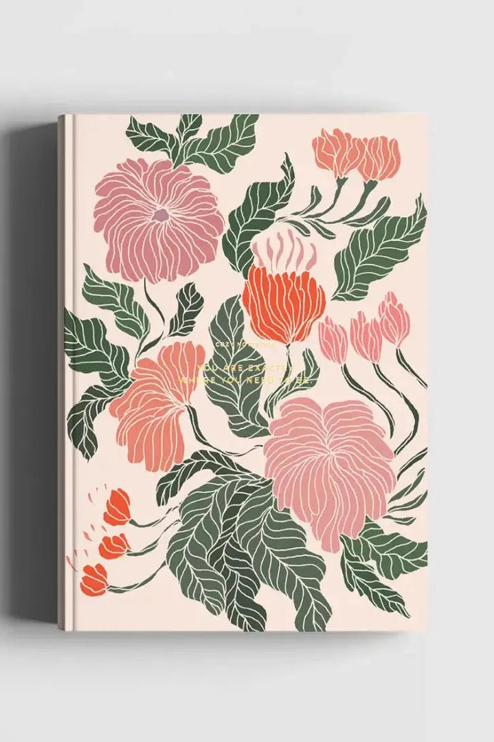 The Floral Peace Lily Notebook shown from the front with its pink flowers and green leaves on beige.