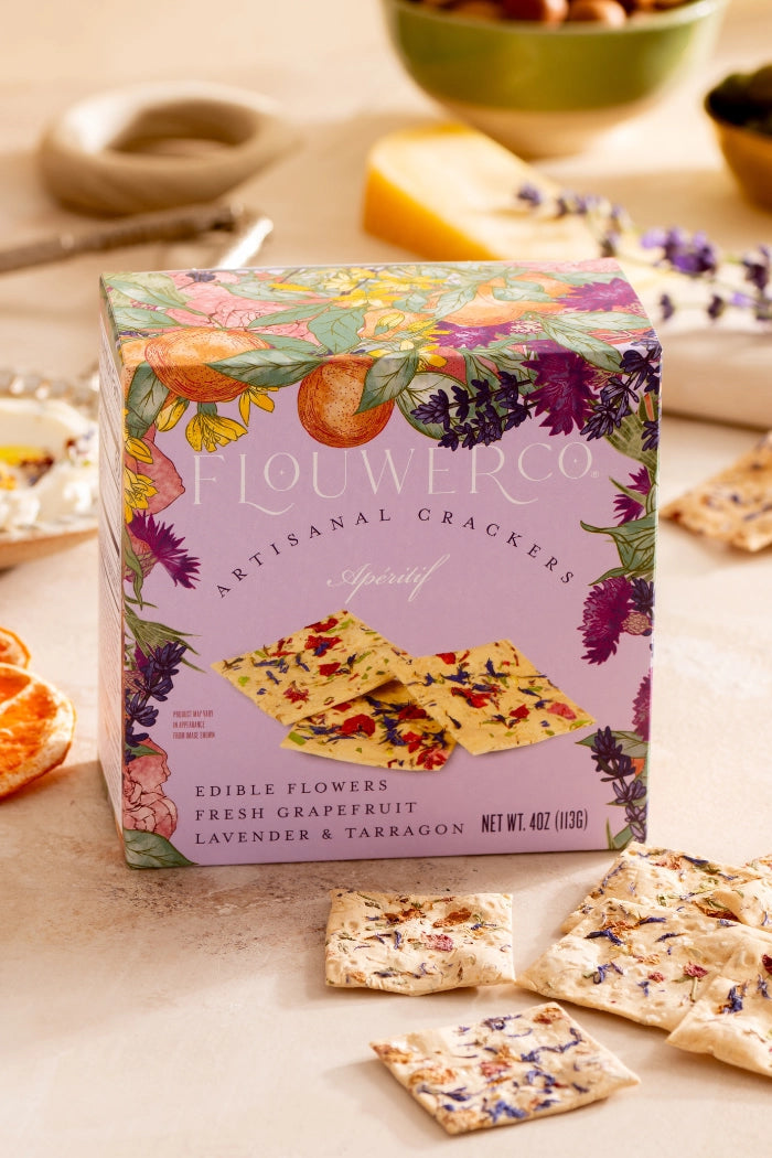 Box of Flouwer Artisanal Crackers on a table with crackers and snacks. ©Flouwer Co.