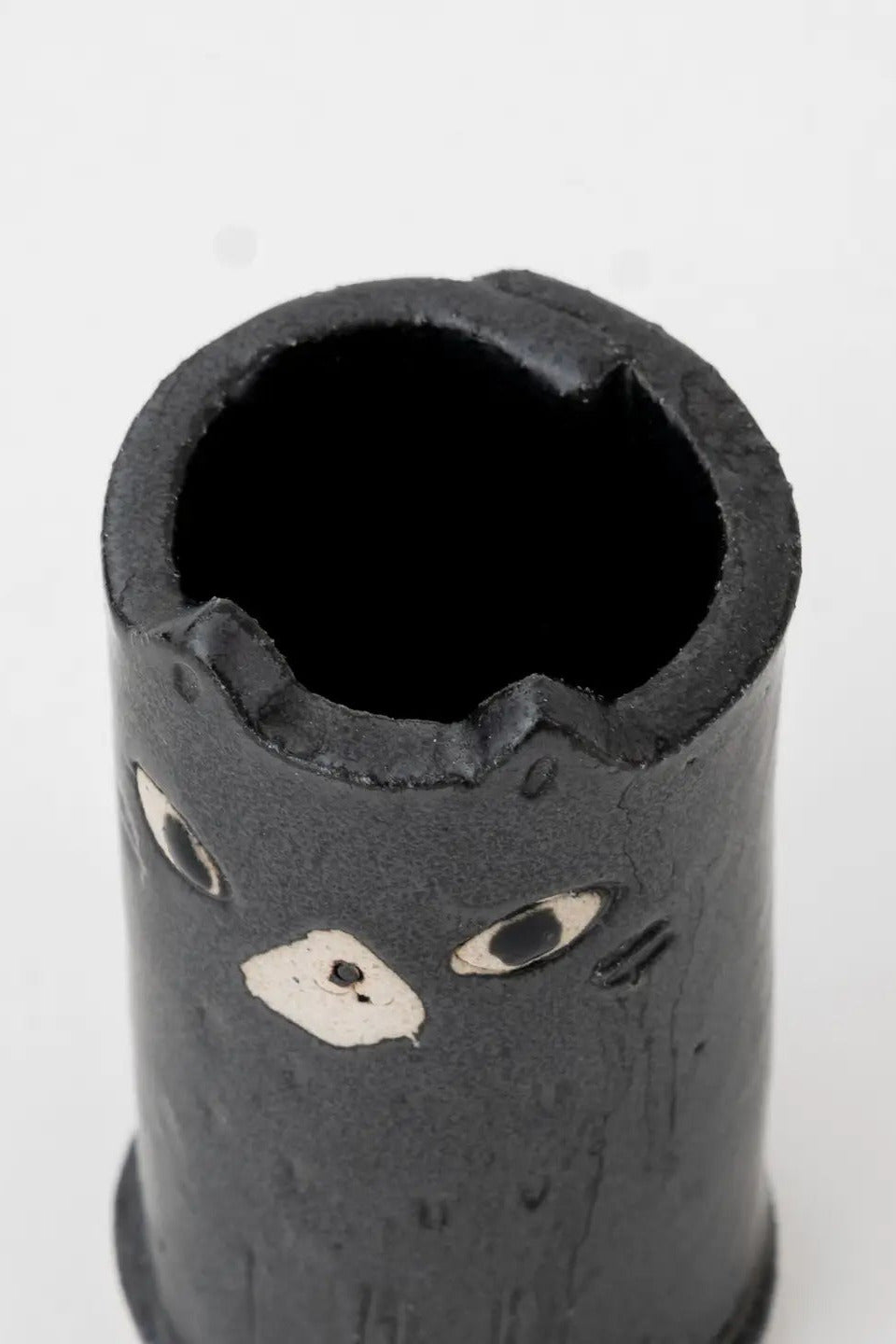 Black cylindrical vase with cat face design on a white background ©Great Zakka