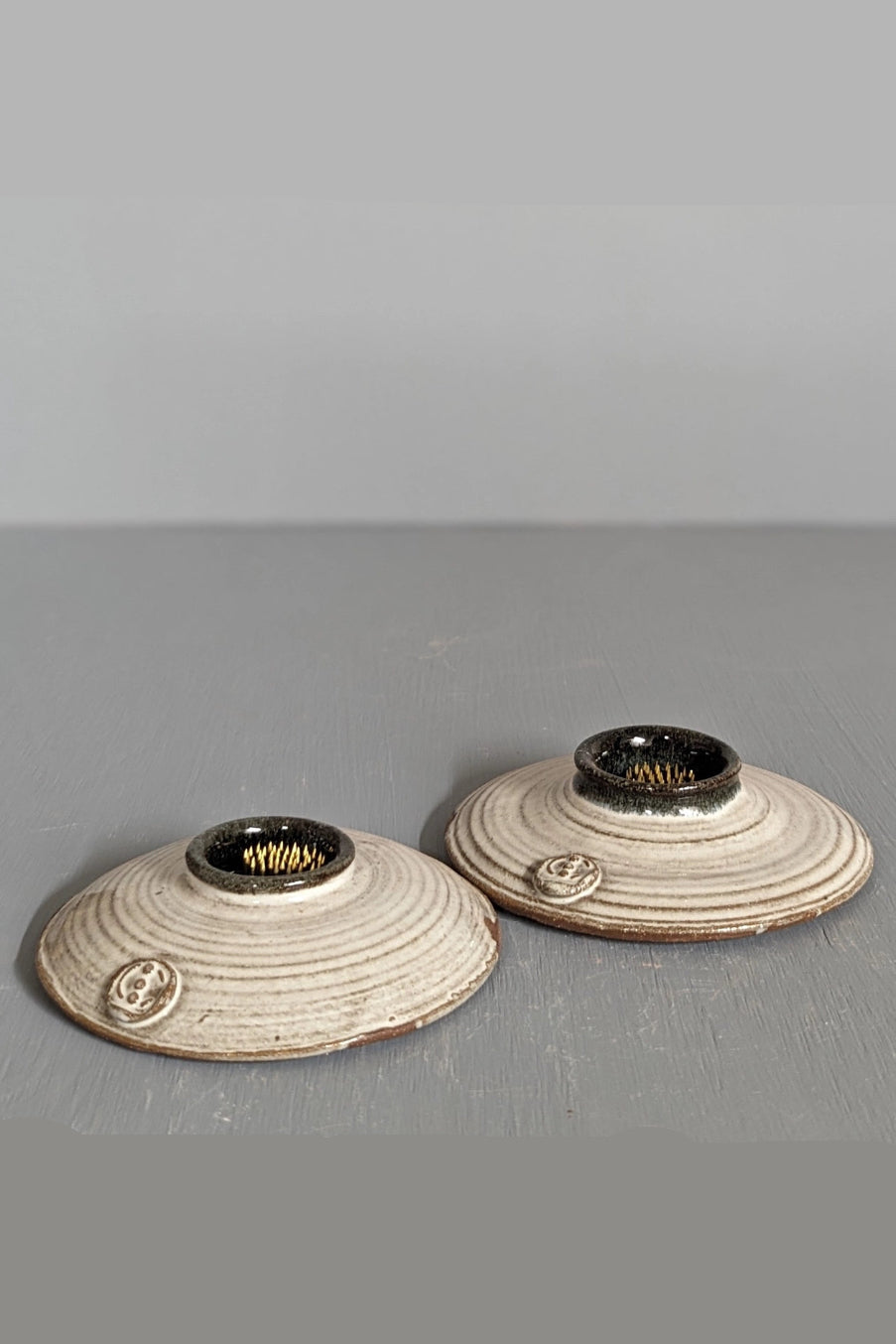 Two ceramic Ikebana bud vases with textured surfaces on a gray surface. ©South Creek Studios