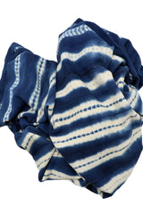 A scrunched up Indigo Tye Dyed Mud Cloth on a white backdrop.