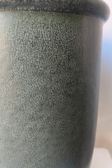 Detail shot of the reactive green glaze on the stoneware dark green urn vase. 