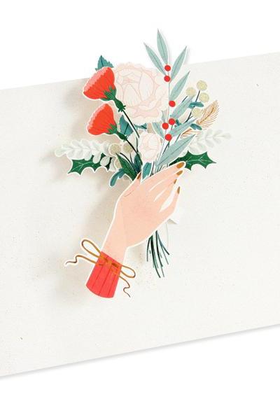 The pop up Offering Hand Holiday Pop up card showing the inside with a bunch of floral and a had holding it. 