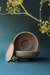 Two raw Ada bowls and saucers by Bergs Potter and a dill plant in the foreground.